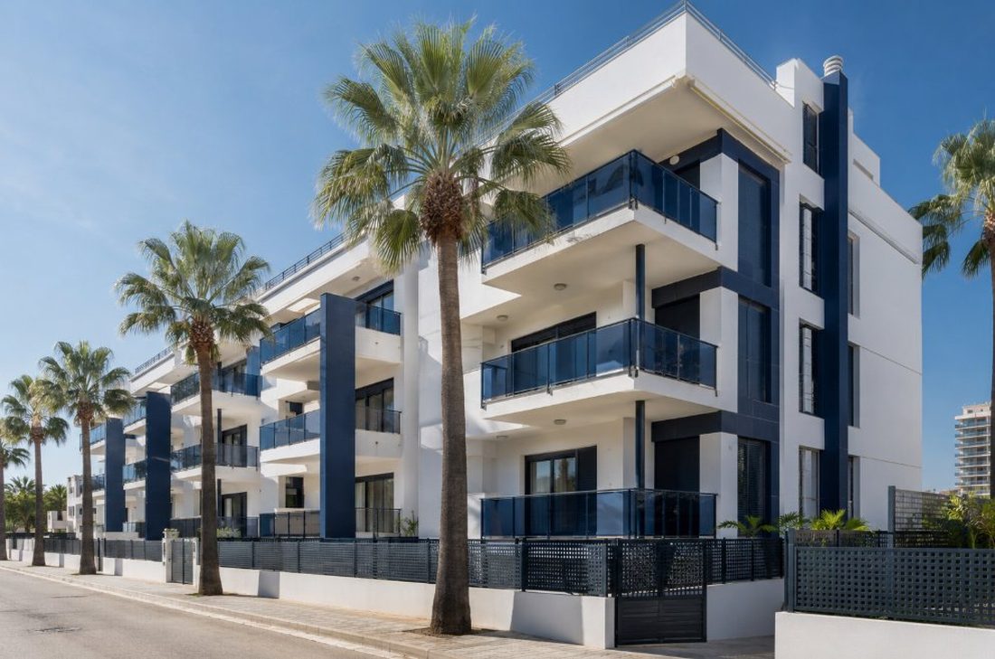 Edificio de apartamentos en La Pineda con fachada y balcones pintados frente al mar