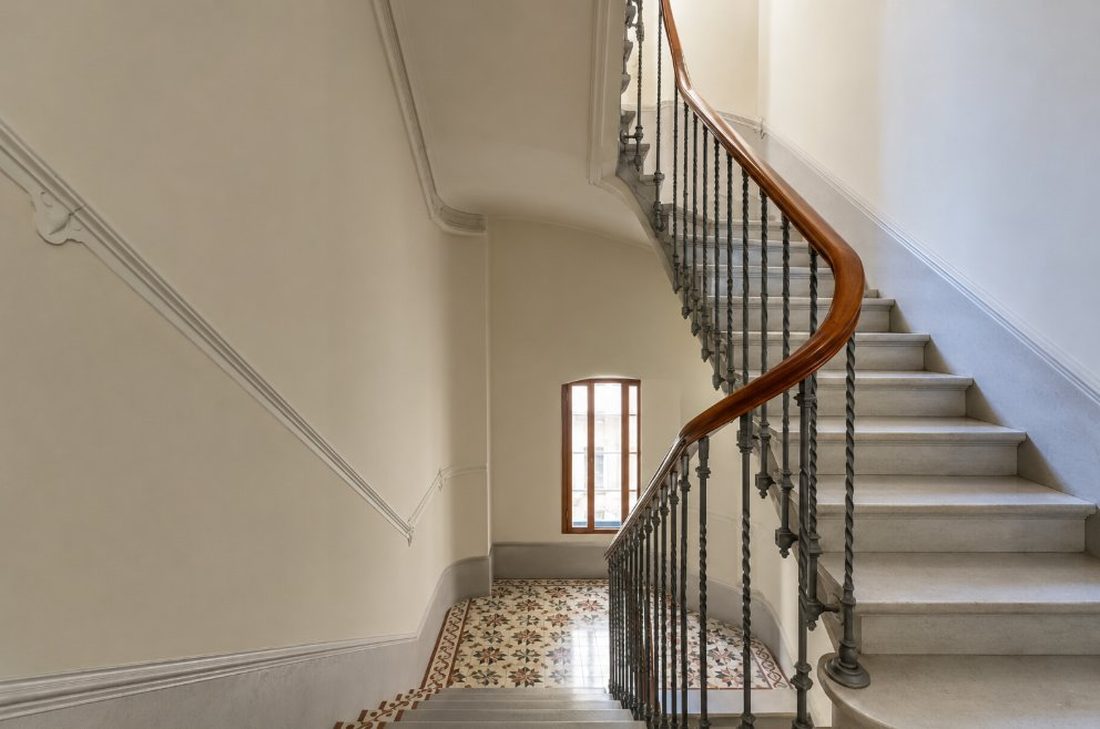 Escalera de comunidad de vecinos en Reus con barandilla restaurada y paredes pintadas