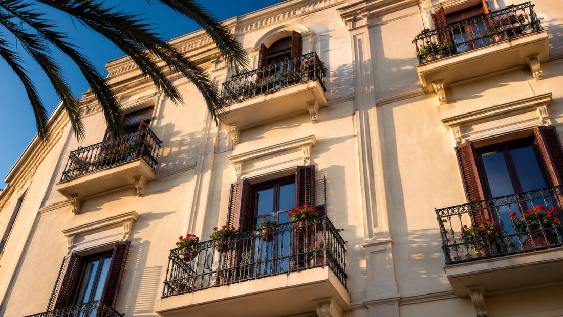 Fachada mediterránea pintada con balcones de hierro forjado en Cambrils